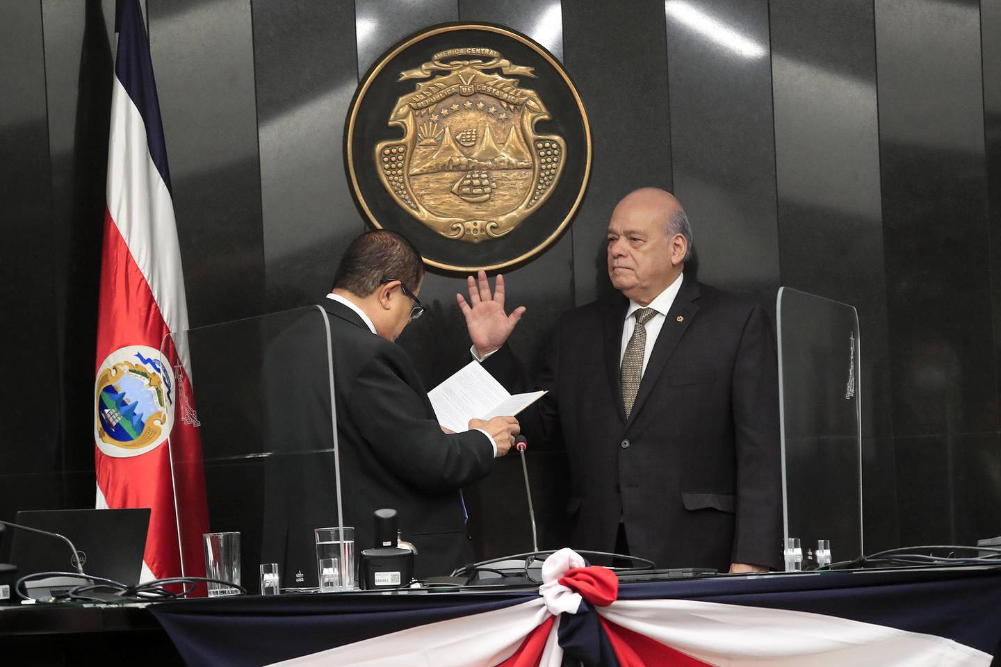 Un hombre en traje parado enfrente de un micrófono
Descripción generada automáticamente con confianza media